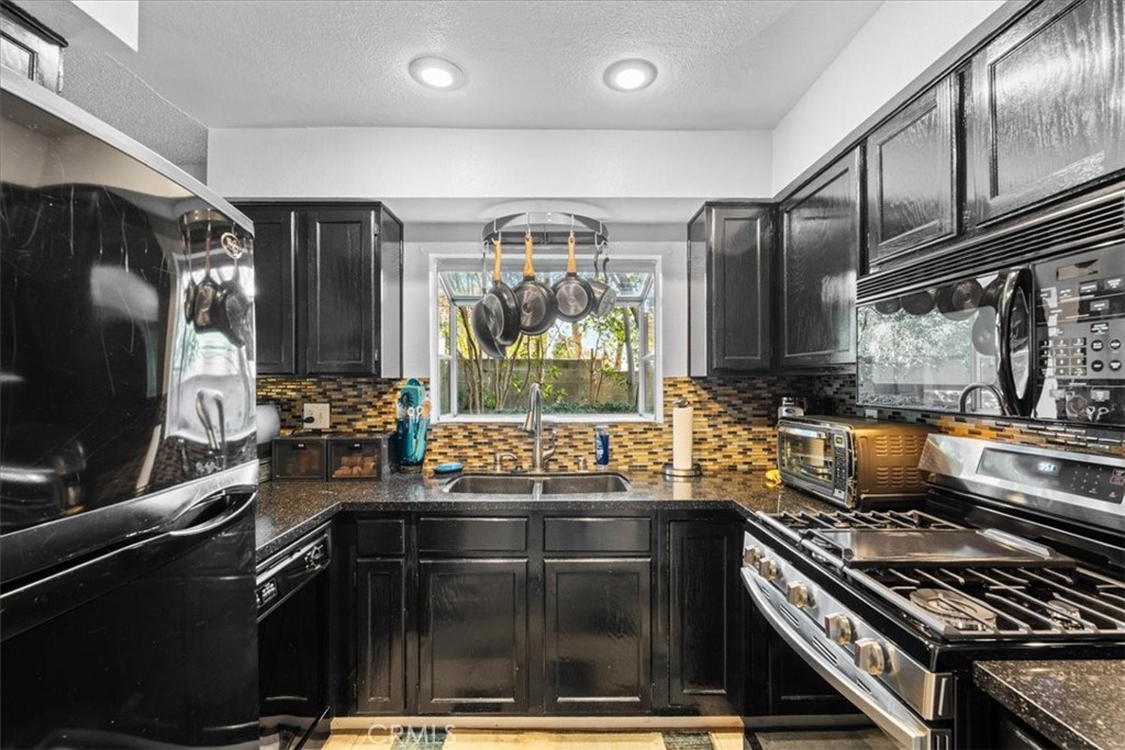6433 Aleatico Place Rancho Cucamonga, CA 91737 - Photo 10 of 39 a kitchen with stainless steel appliances a stove a sink and a microwave