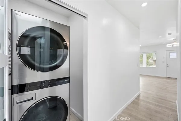 a utility room with mirror and a washer dryer