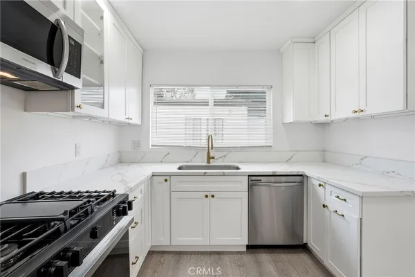 a kitchen with stainless steel appliances granite countertop a sink stove and cabinets
