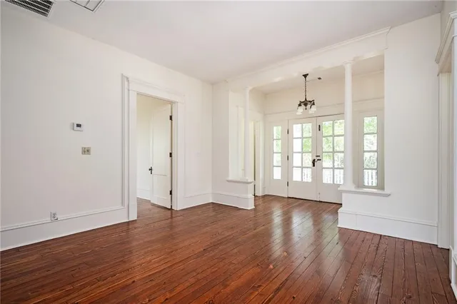 a view of a hallway with wooden floor and closet