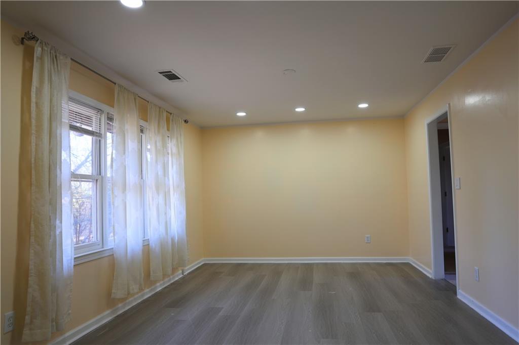 4296 Linda Lane Southwest Lilburn, GA 30047 - Photo 18 of 29 an empty room with wooden floor and windows