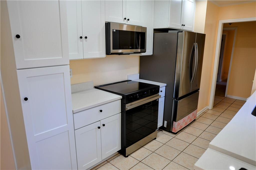 4296 Linda Lane Southwest Lilburn, GA 30047 - Photo 6 of 29 a kitchen with stainless steel appliances a refrigerator stove and microwave