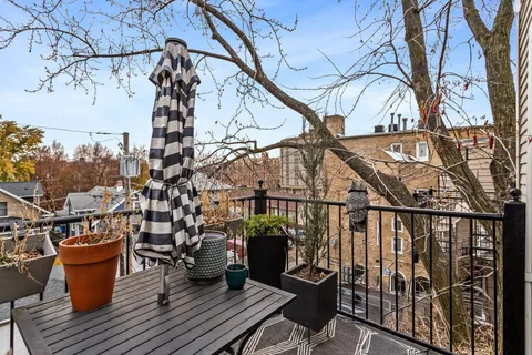 a view of a balcony with chairs and wooden fence