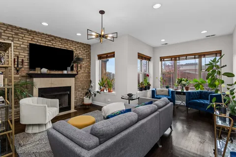 a living room with furniture a flat screen tv and a fireplace