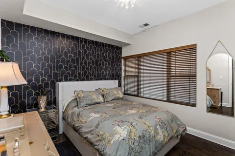 a bedroom with a bed a mirror and a window