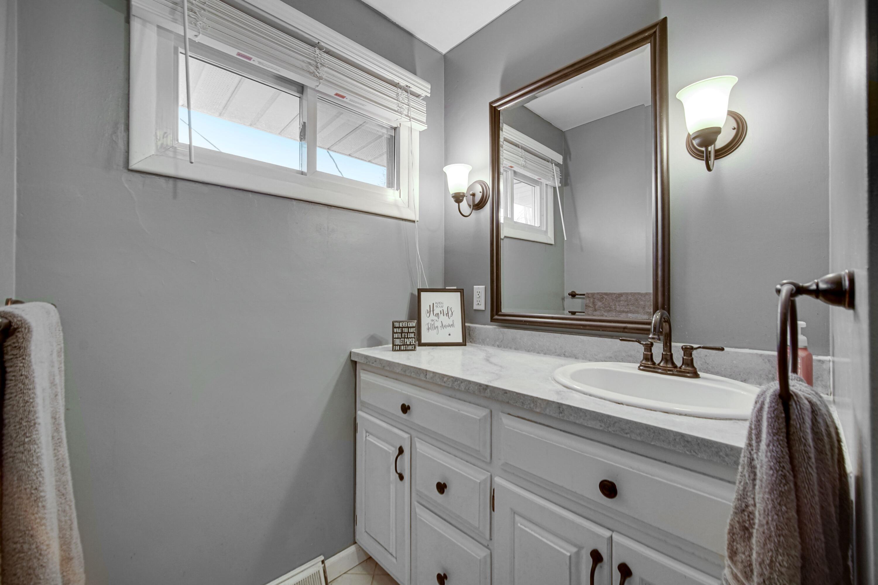 9418 Cleveland Street Crown Point, IN 46307 - Photo 14 of 22 a bathroom with a sink and a mirror