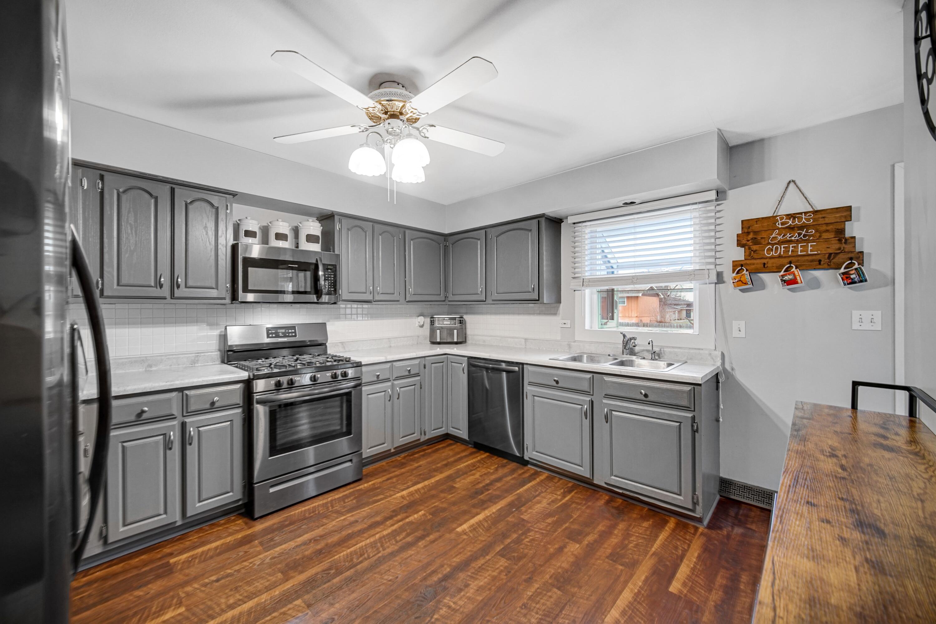 9418 Cleveland Street Crown Point, IN 46307 - Photo 9 of 22 a kitchen with stainless steel appliances granite countertop hardwood floor sink stove and refrigerator