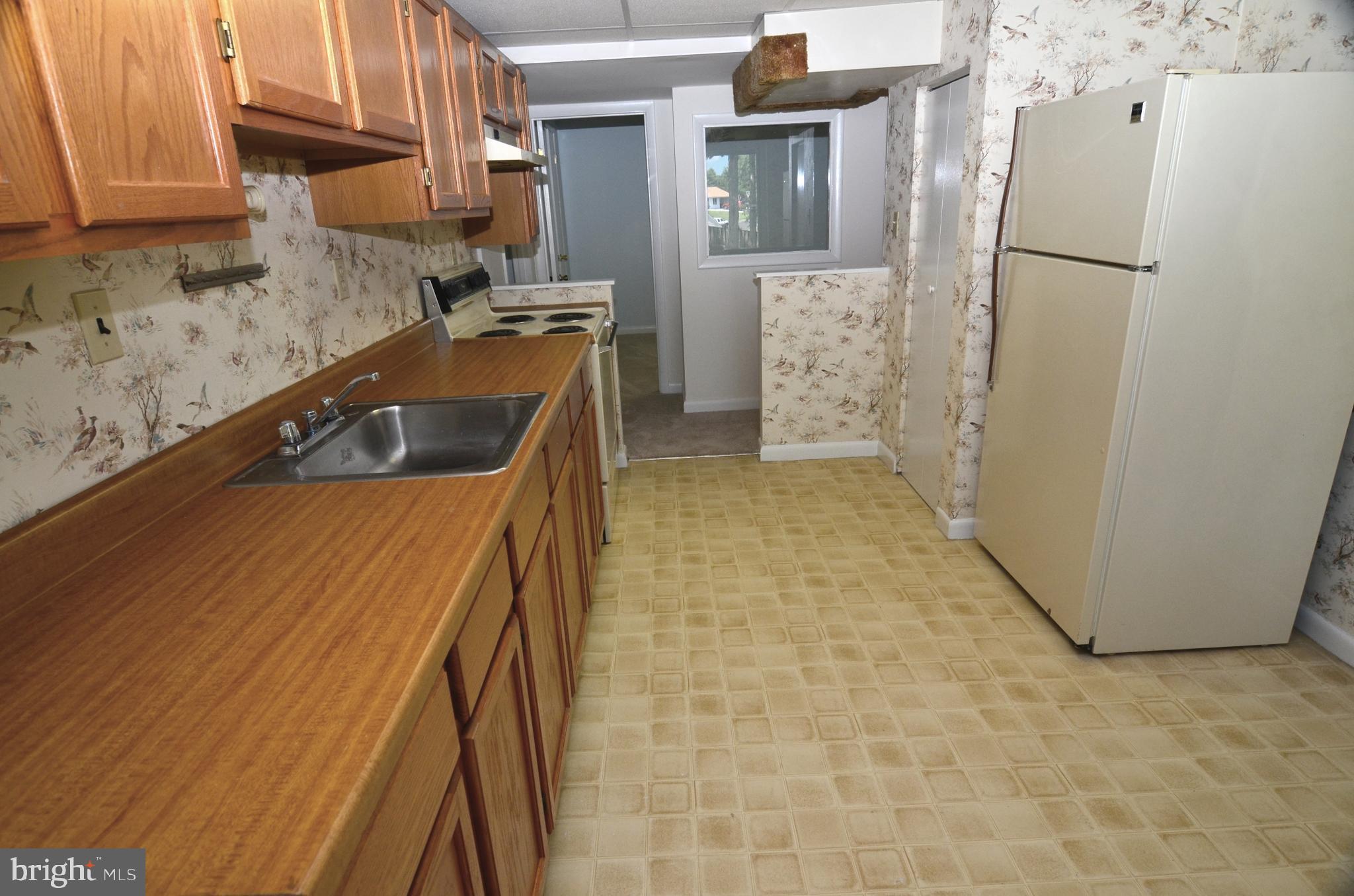 8604 Contee Road Laurel, MD 20708 - Photo 40 of 56 a kitchen with refrigerator a stove a sink and a cabinets