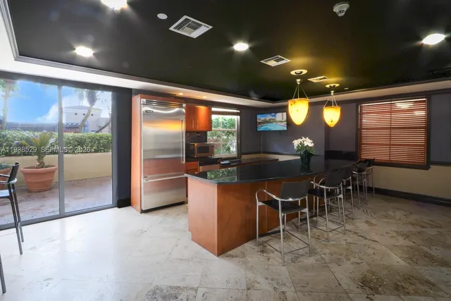 a kitchen with stainless steel appliances kitchen island granite countertop a table and chairs in it