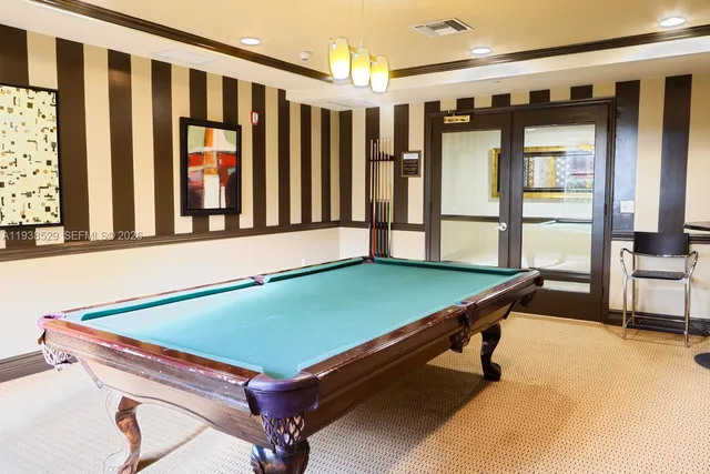 a room with furniture pool table and windows