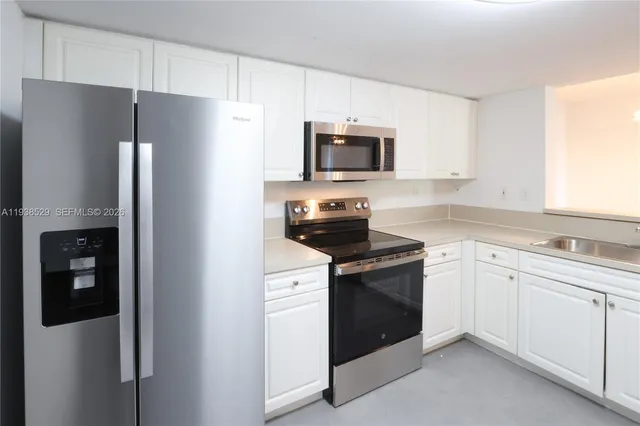 a kitchen with stainless steel appliances a refrigerator stove and microwave