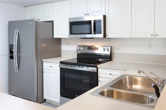 a kitchen with stainless steel appliances granite countertop a refrigerator stove and microwave