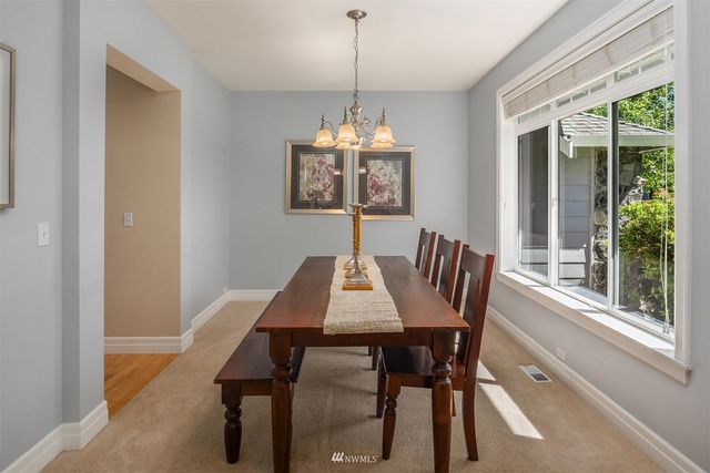 a dining room with furniture a chandelier and wooden floor
