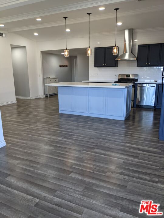 892 Vassar Street Pomona, CA 91767 - Photo 5 of 28 a large kitchen with stainless steel appliances wooden cabinets and a wooden floor