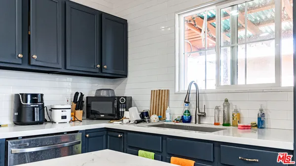 a kitchen with stainless steel appliances sink cabinets and window
