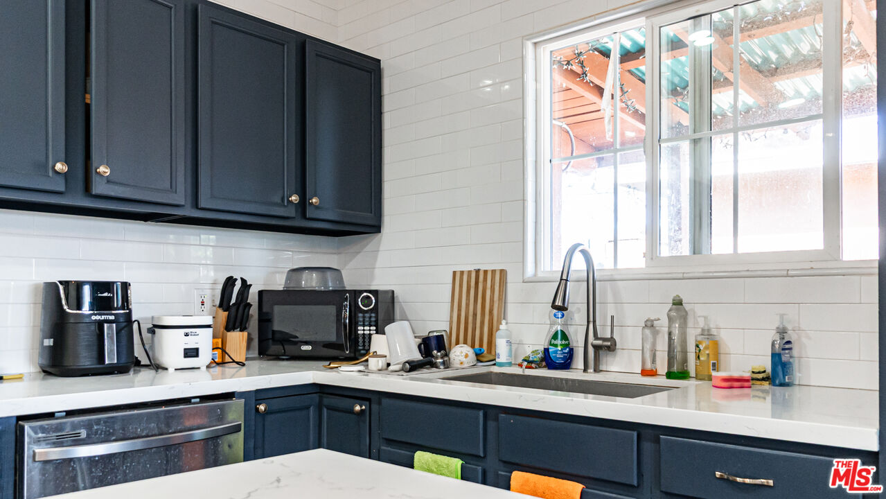 892 Vassar Street Pomona, CA 91767 - Photo 7 of 28 a kitchen with stainless steel appliances sink cabinets and window