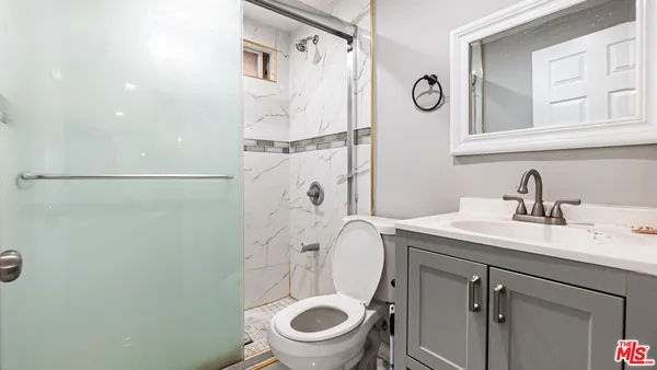 a bathroom with a granite countertop toilet sink and a mirror