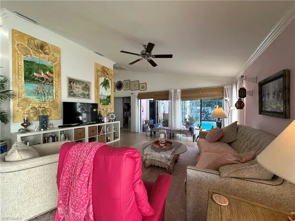 a living room with furniture a flat screen tv and a large window