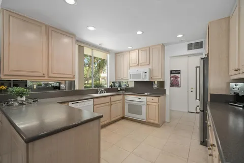 a kitchen with a refrigerator sink and cabinets