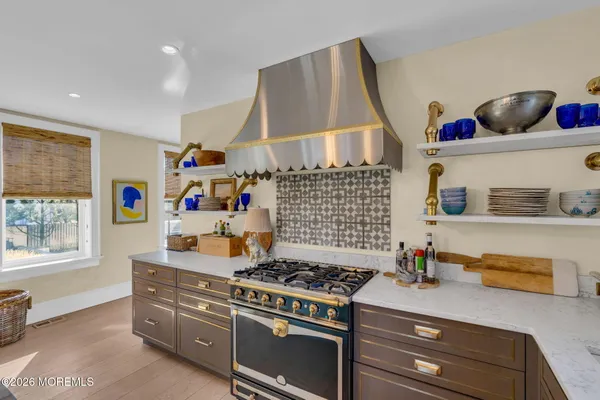 a kitchen with stainless steel appliances kitchen island granite countertop a table chairs and a refrigerator