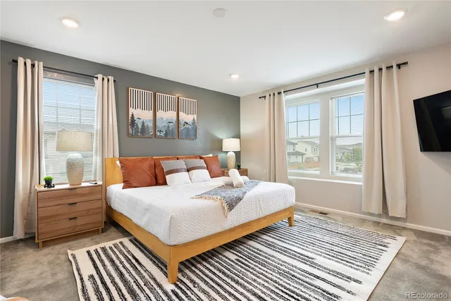 a bedroom with a large bed and a flat tv screen