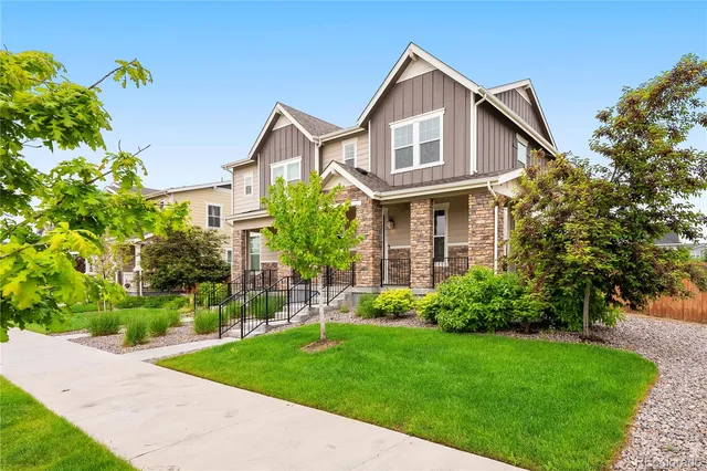 a front view of a house with a yard and trees