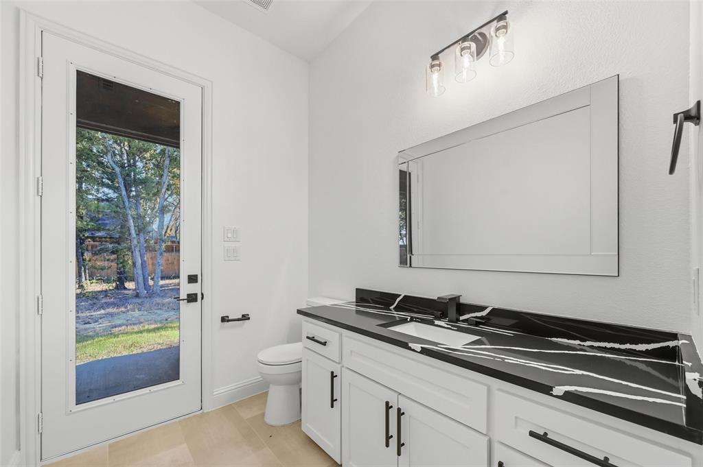 300 Seacross Court Combine, TX 75159 - Photo 32 of 39 a bathroom with a granite countertop sink a toilet and a mirror