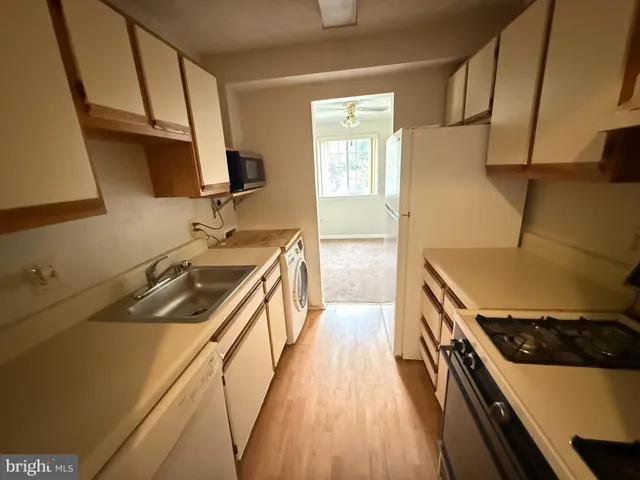 a kitchen with a sink stove top oven and cabinets