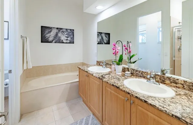 a bathroom with a granite countertop tub sink and mirror