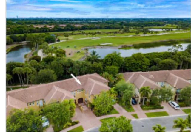 an aerial view of a house with a yard and lake view