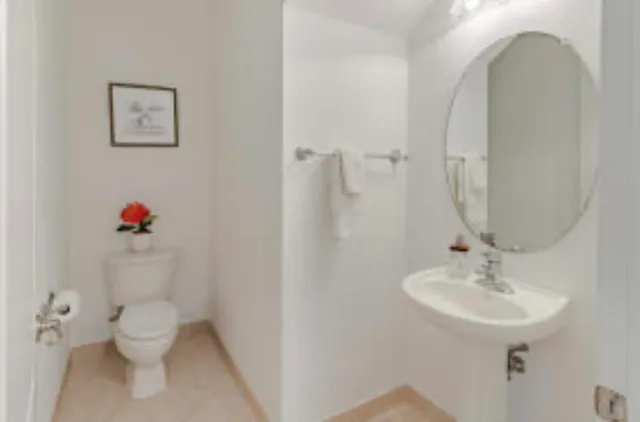 a bathroom with a sink mirror and toilet