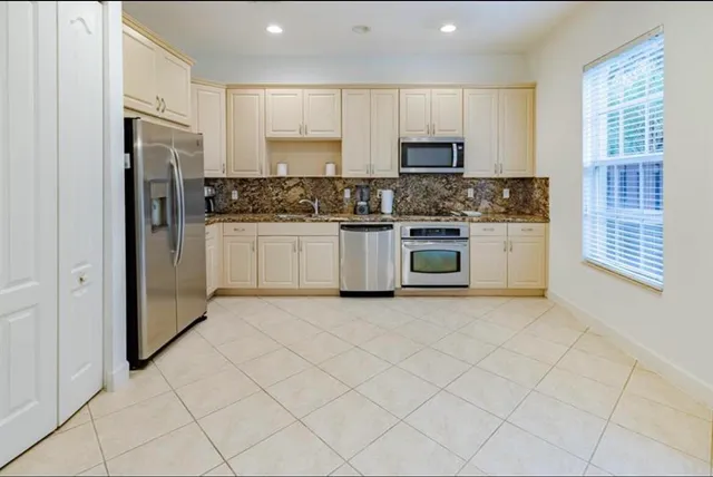 a kitchen with stainless steel appliances granite countertop a refrigerator and a stove top oven