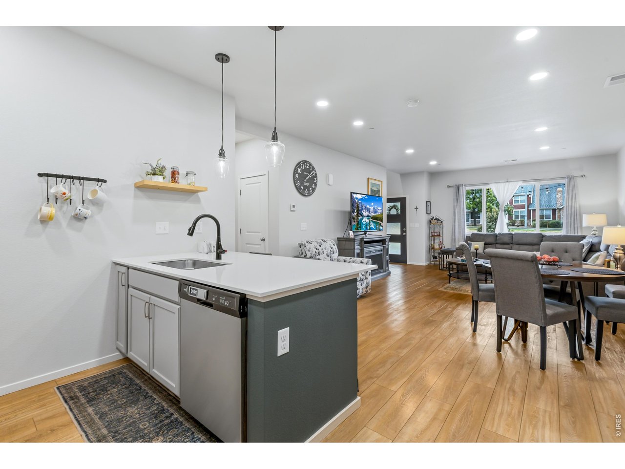 6609 4th St Road, Unit 4 Greeley, CO 80634 - Photo 15 of 41 a kitchen with a sink a stove a dining table and chairs