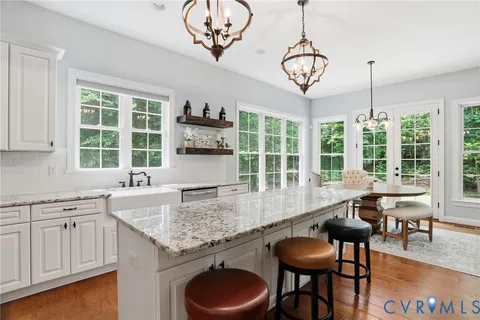 a view of kitchen with refrigerator a sink dishwasher a dining table and chairs