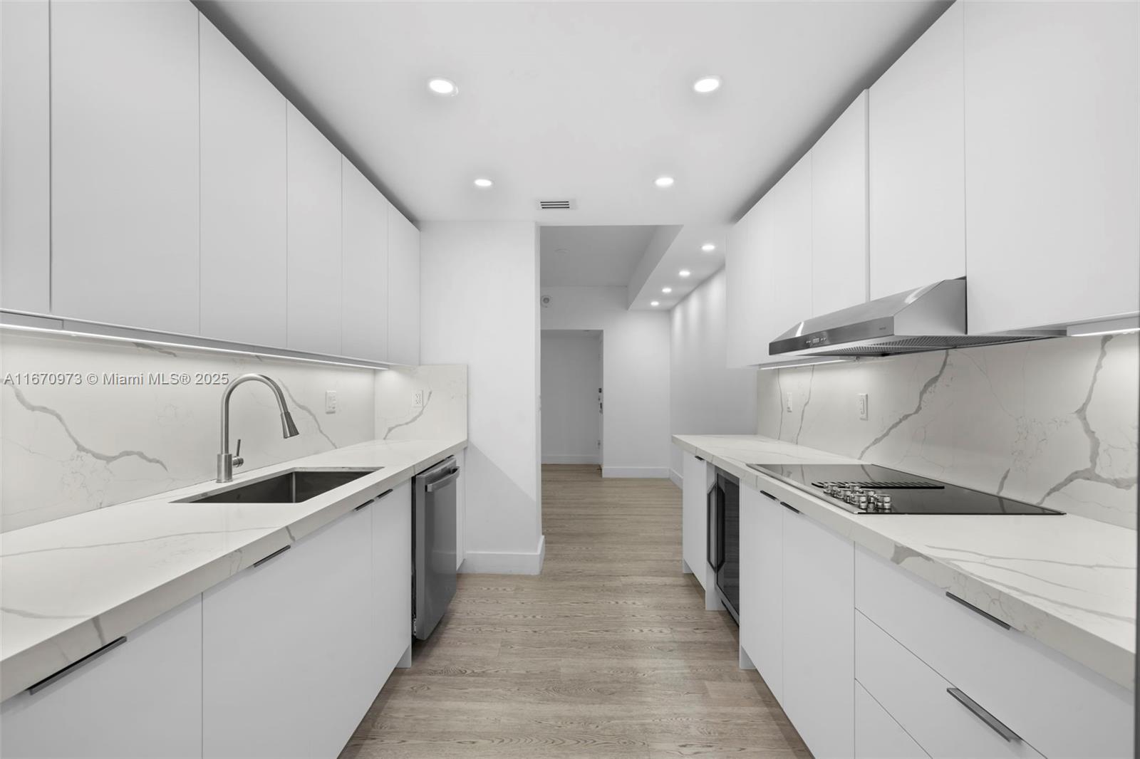 1121 Crandon Boulevard, Unit E105 Key Biscayne, FL 33149 - Photo 24 of 43 a kitchen with stainless steel appliances granite countertop a sink and a refrigerator