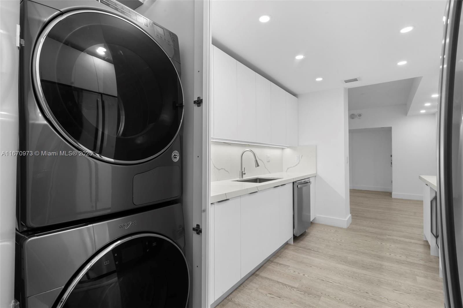 1121 Crandon Boulevard, Unit E105 Key Biscayne, FL 33149 - Photo 25 of 43 a kitchen with a washer and dryer