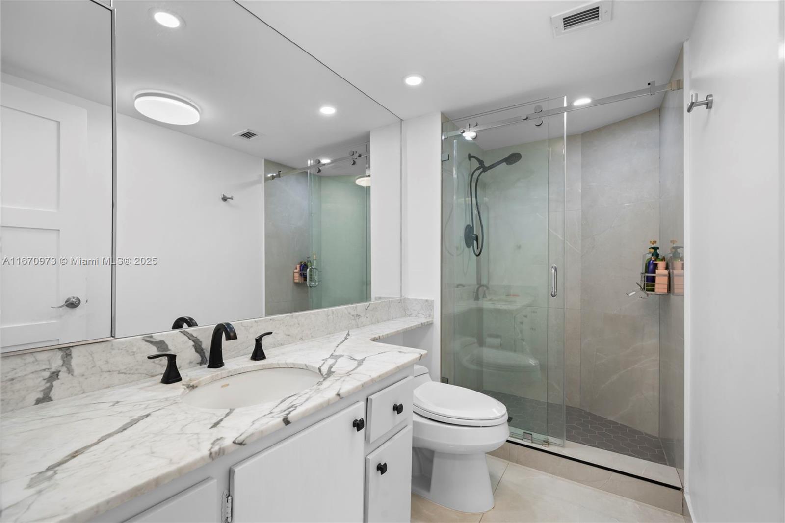 1121 Crandon Boulevard, Unit E105 Key Biscayne, FL 33149 - Photo 26 of 43 a bathroom with a granite countertop sink mirror and toilet