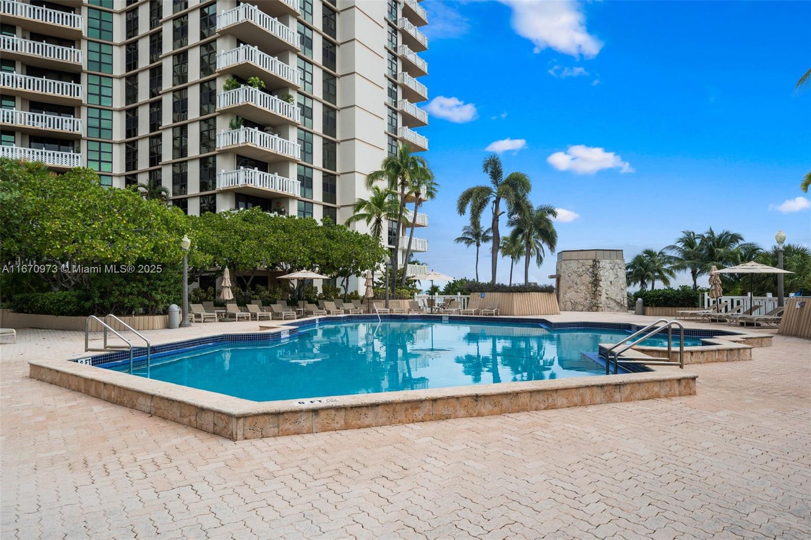 1121 Crandon Boulevard, Unit E105 Key Biscayne, FL 33149 - Photo 34 of 43 a view of a swimming pool with a lounge chairs
