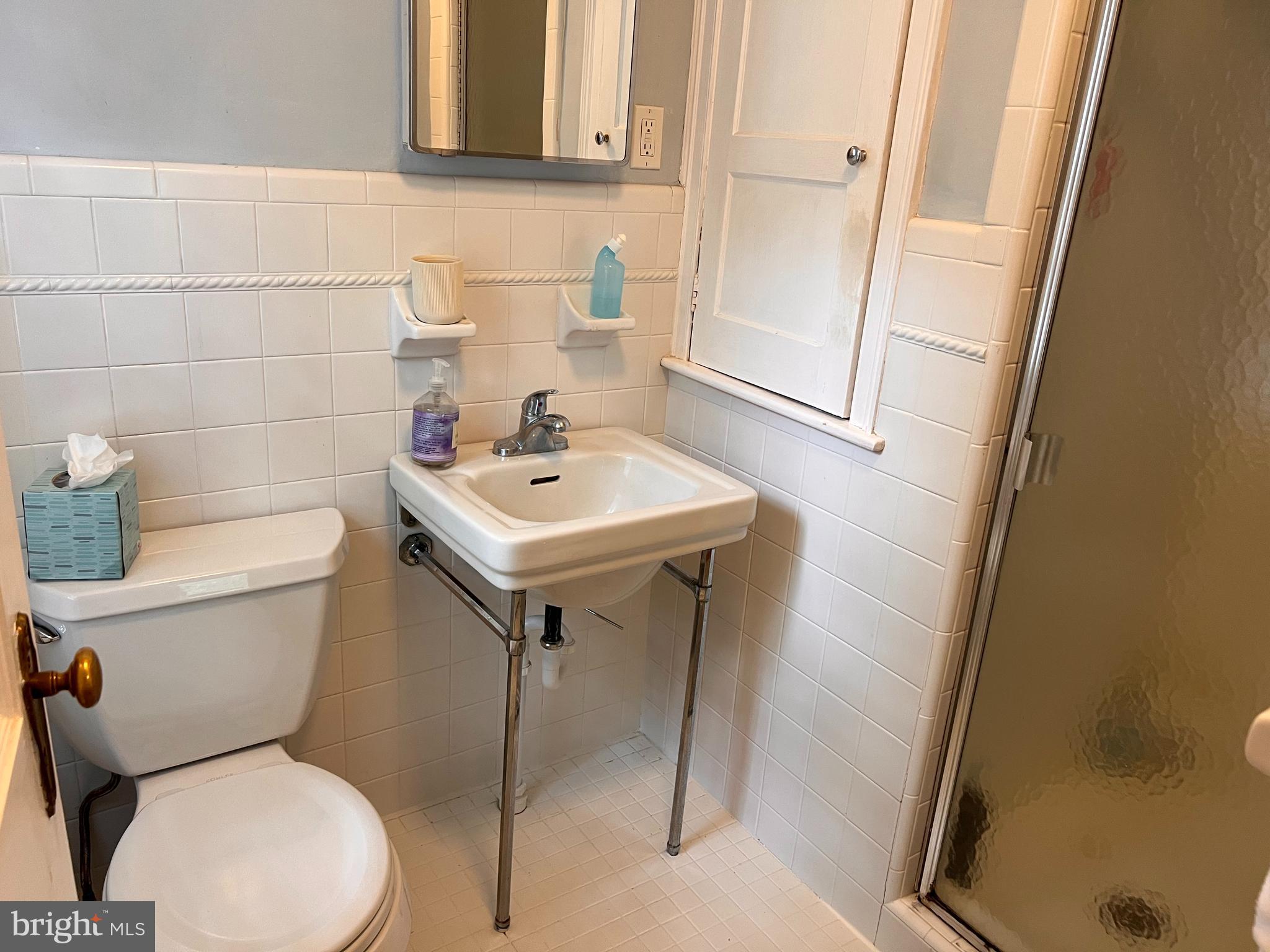 112 Hilltop Road Philadelphia, PA 19118 - Photo 10 of 13 a white toilet sitting next to a bathroom sink