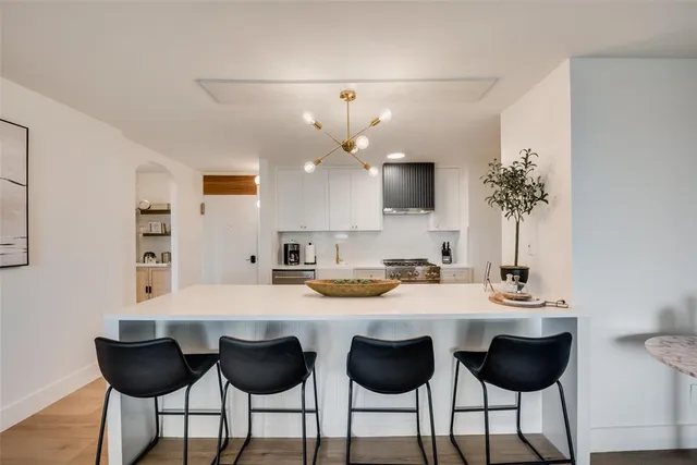 a kitchen with granite countertop a table chairs stove and cabinets