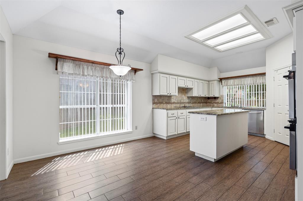 7948 Morning Lane Fort Worth, TX 76123 - Photo 11 of 32 a kitchen with wooden floors and white cabinets
