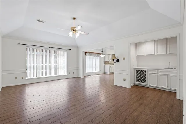 a view of an empty room with window and wooden floor
