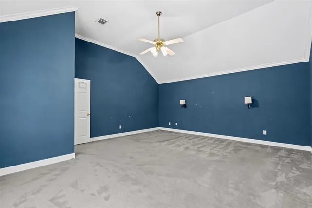 a view of an empty room with a chandelier fan