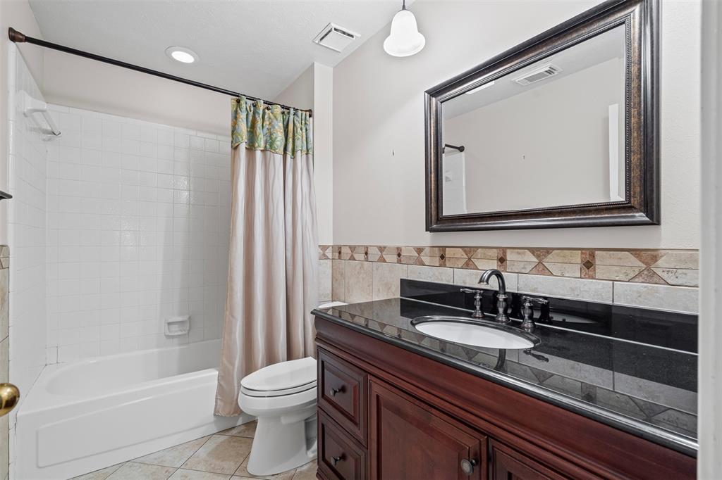 7948 Morning Lane Fort Worth, TX 76123 - Photo 28 of 32 a bathroom with a granite countertop sink toilet and shower