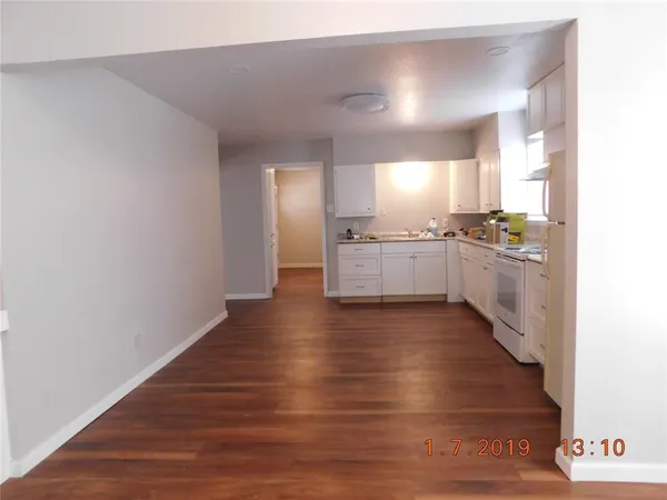 a large kitchen with hardwood floor and a sink