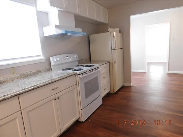 a kitchen with granite countertop white cabinets and white appliances