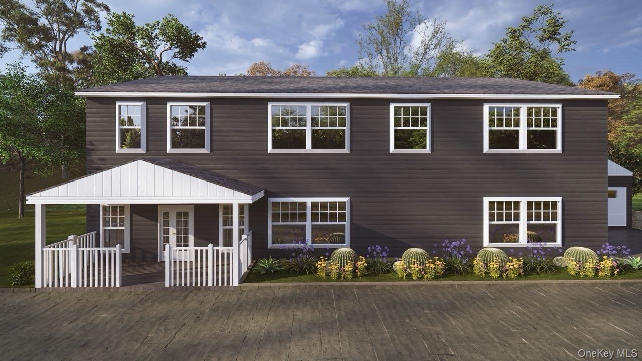 a front view of a house with a garden and yard