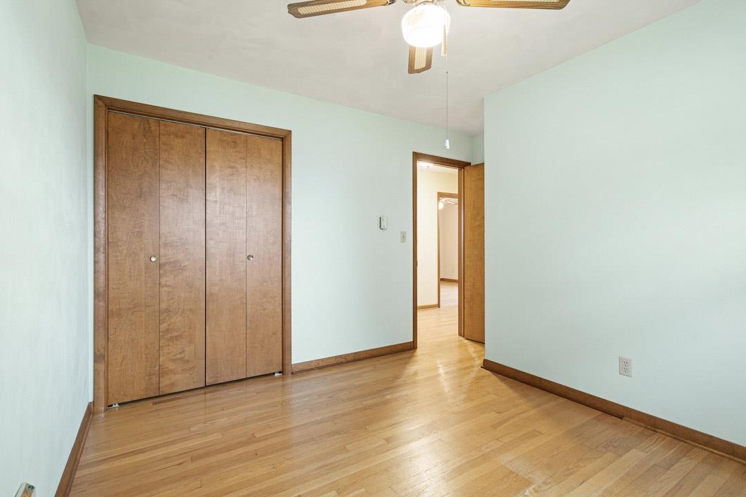 5618 North Armour Road Stillman Valley, IL 61084 - Photo 15 of 29 an empty room with wooden floor chandelier fan and windows