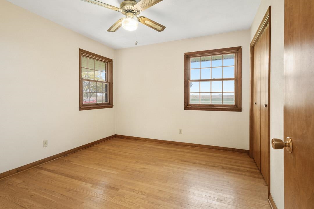 5618 North Armour Road Stillman Valley, IL 61084 - Photo 21 of 29 an empty room with wooden floor fan and windows