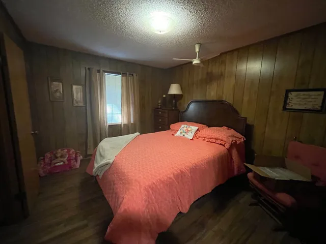 a bed sitting in a spacious bedroom next to a window